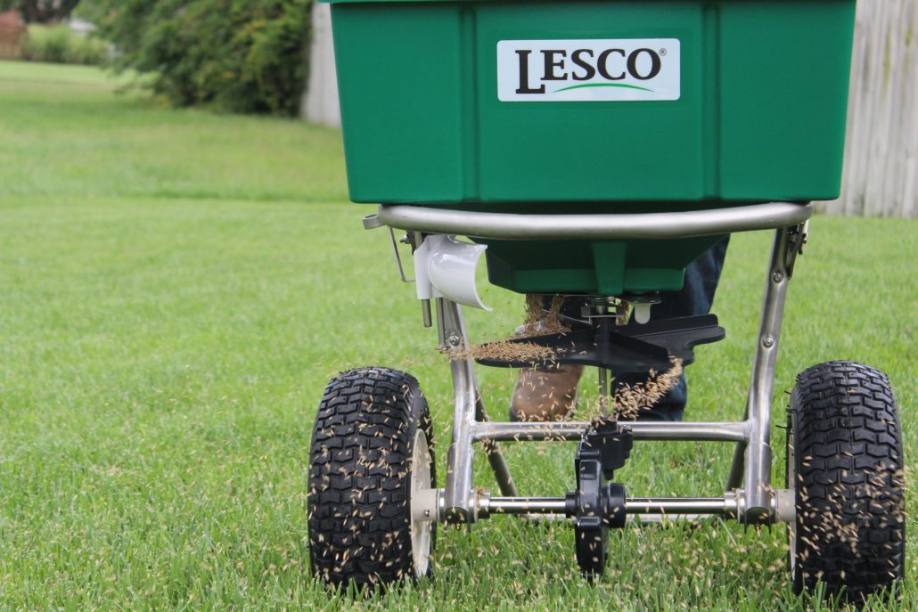A photo of a push behind seeder spreading fescue seed into a lawn by PURE Lawn Management